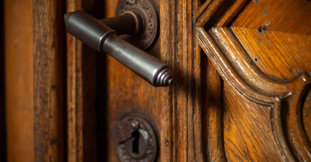 Gros plan sur une poignée de porte en bois ornée à Wrocław, en Pologne, témoignant d'un savoir-faire artisanal.