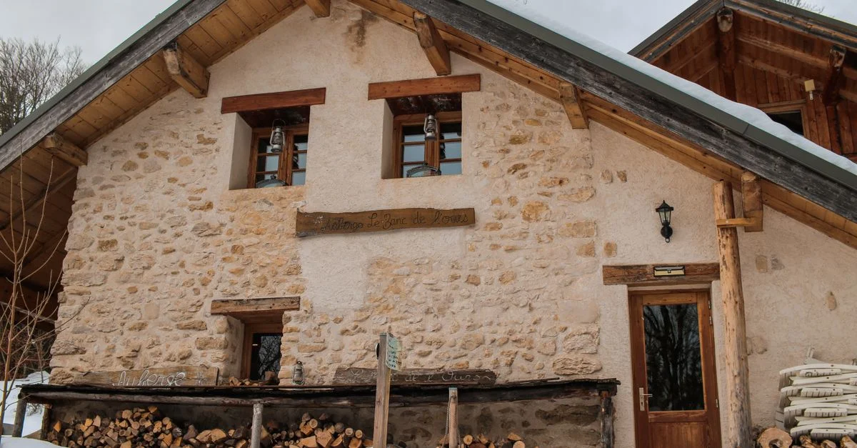 Maison rustique en pierre dans un paysage enneigé, Autrans-Méaudre-en-Vercors, France.