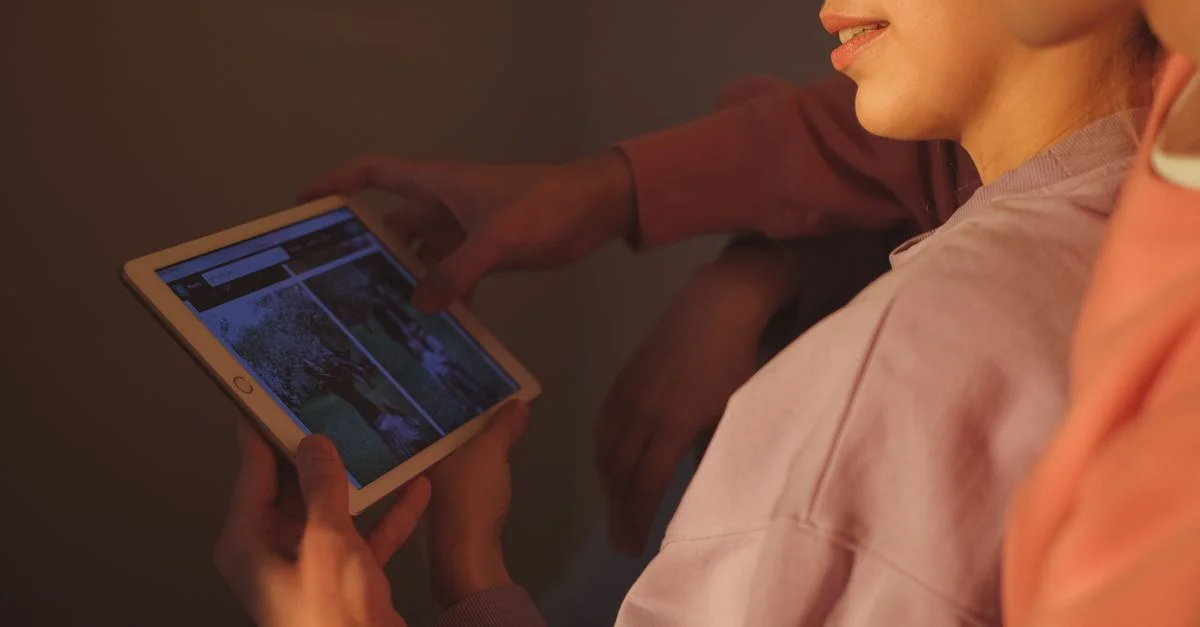 Un couple utilisant une tablette ensemble dans un cadre intérieur confortable, profitant de la technologie.
