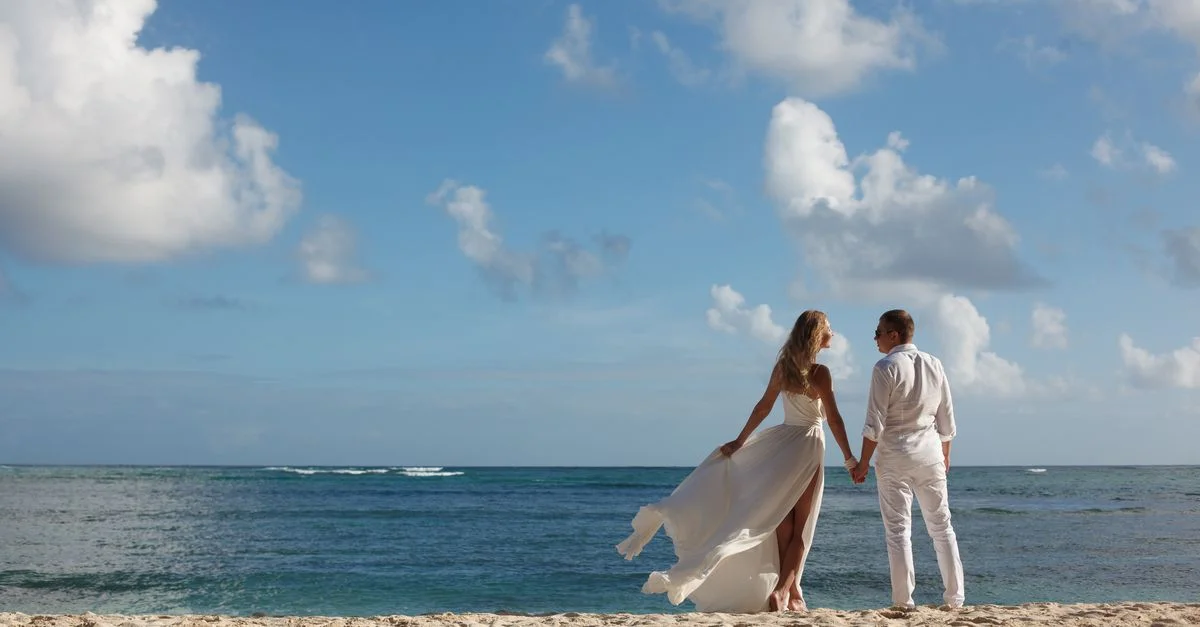 Un couple profite de son mariage sur une plage ensoleillée de République dominicaine. Idéal pour les thèmes de l'amour et du voyage.