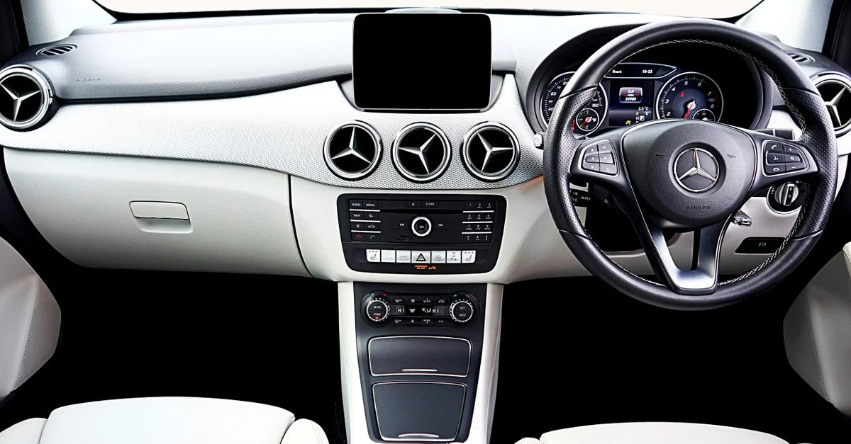 Photographie haute qualité de l'intérieur moderne d'une voiture Mercedes-Benz mettant en valeur le tableau de bord et le volant.