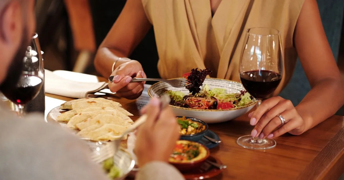 Couple profitant d'un dîner romantique avec du vin et de délicieux plats dans un restaurant cosy.