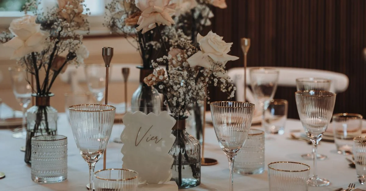 Mise en table luxueuse avec des roses et de la verrerie pour une réception de mariage.