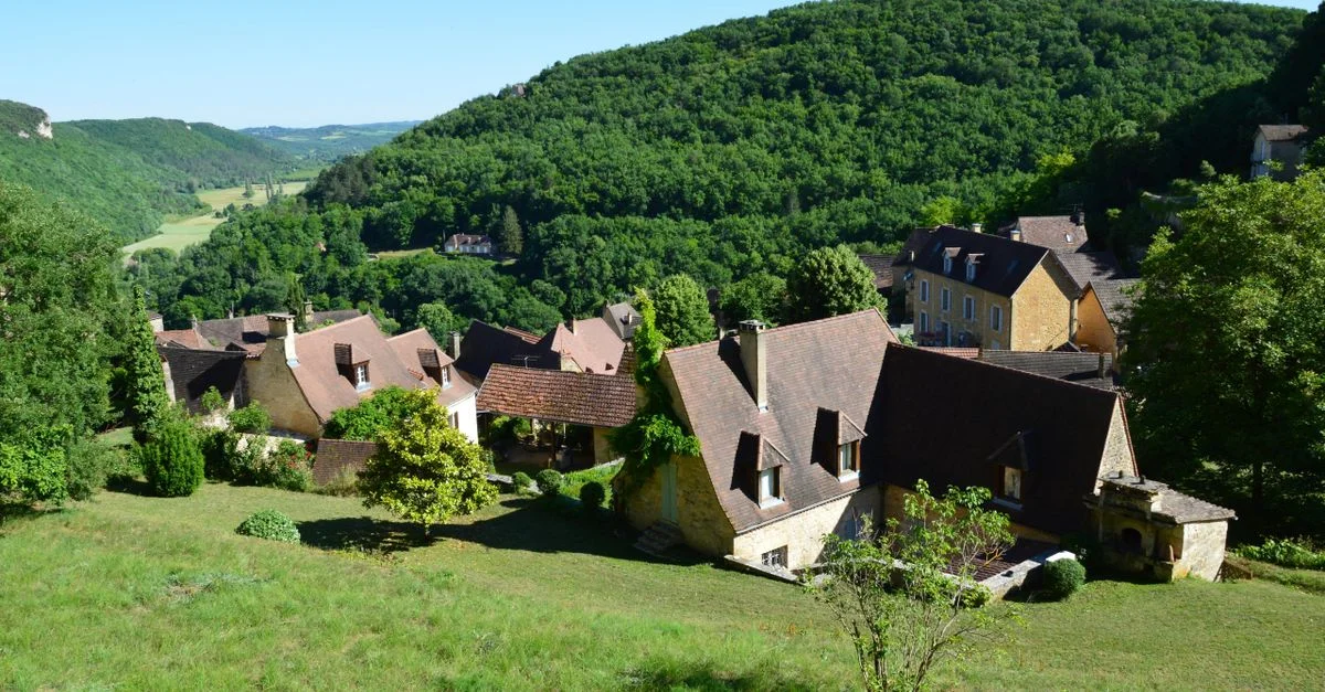 Une vue aérienne pittoresque d'un village pittoresque entouré de collines verdoyantes.