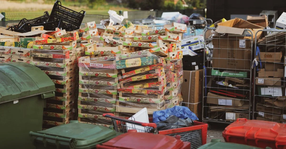 Empilements de cartons et de bacs dans une zone de stockage extérieure, exemplifiant la gestion des déchets.