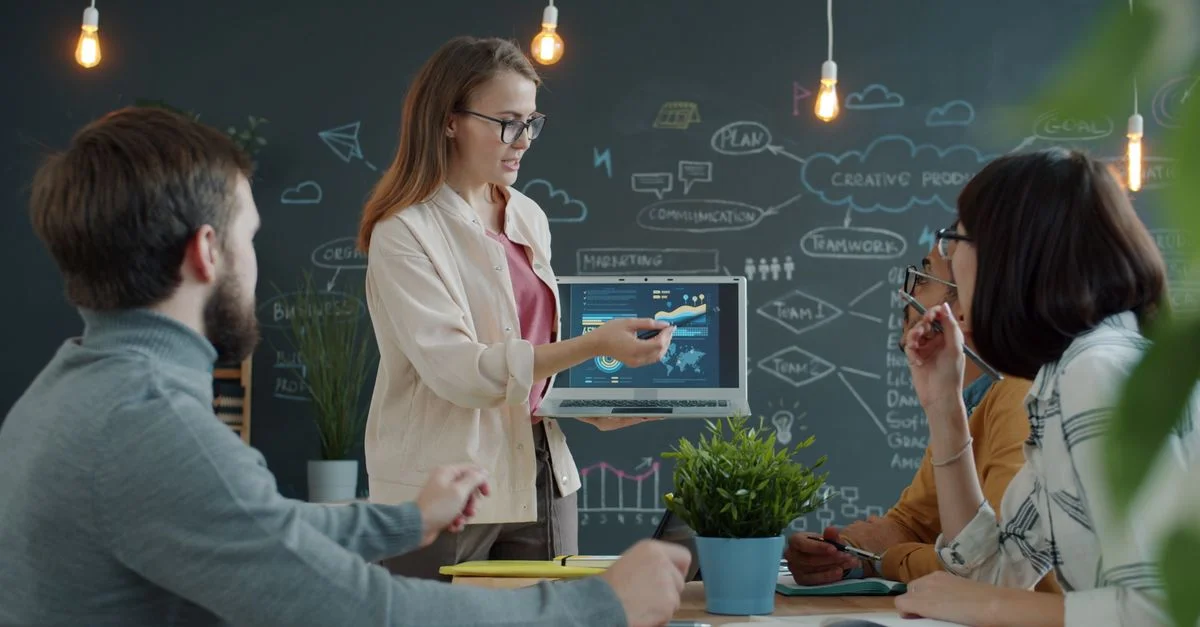 Une équipe diversifiée collaborant avec des outils numériques dans un environnement de bureau créatif.