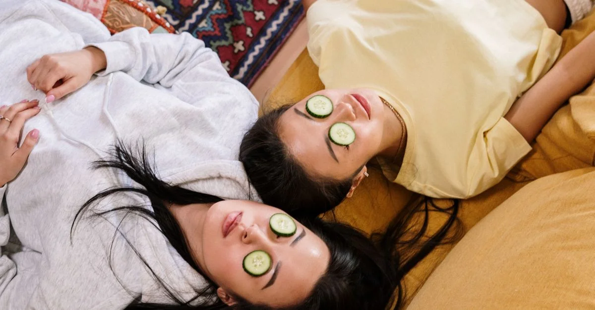 Deux amis se détendent à la maison avec des masques au concombre dans un cadre cosy, profitant d'une session de soins de la peau DIY.
