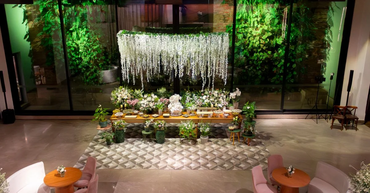 Zone de réception de mariage luxueuse à São Paulo avec des arrangements floraux élégants et des sièges stylés.