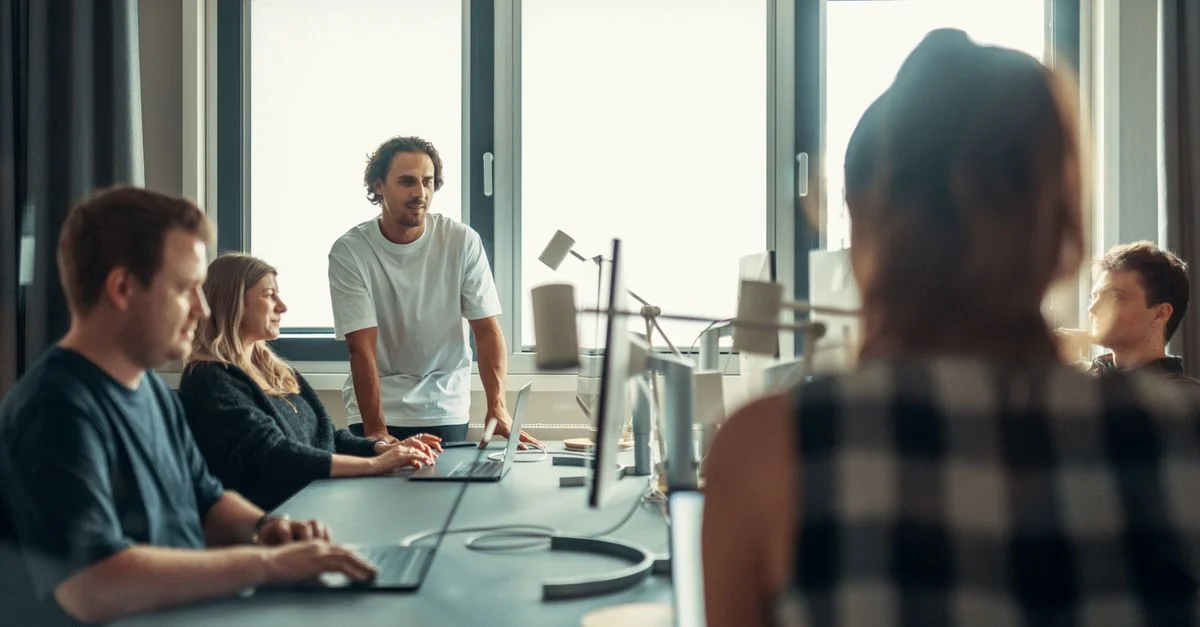 Une équipe diversifiée engagée dans une discussion lors d'une réunion de bureau collaborative.